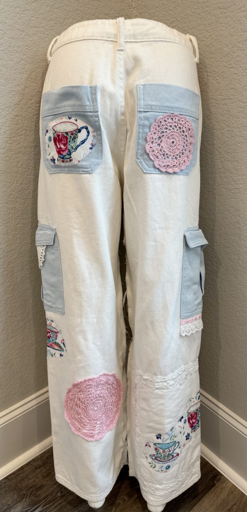 A pair of white pants with pink and blue appliques.