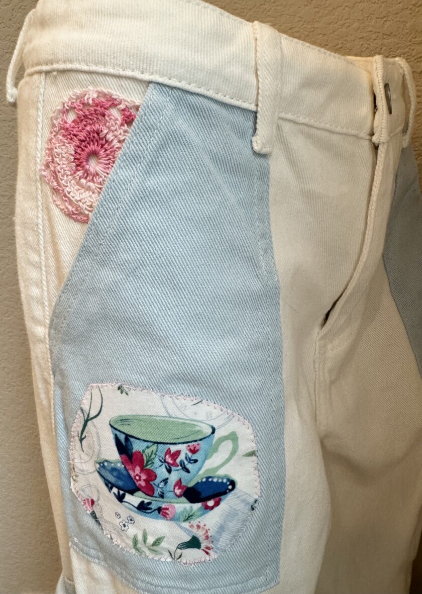 A pair of shorts with a tea cup on the pocket.