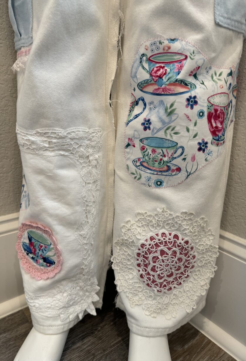 A pair of white jeans with tea cups on them.