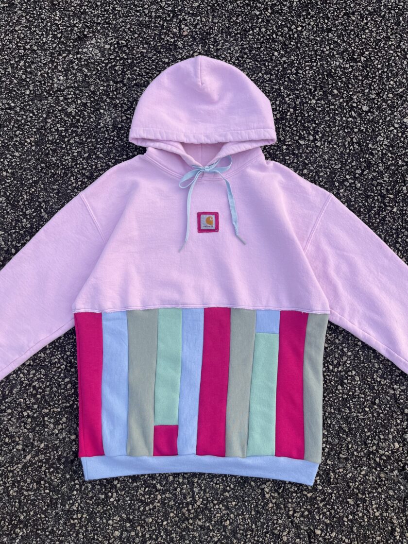 A pink hoodie with a pink, blue, and green stripe.