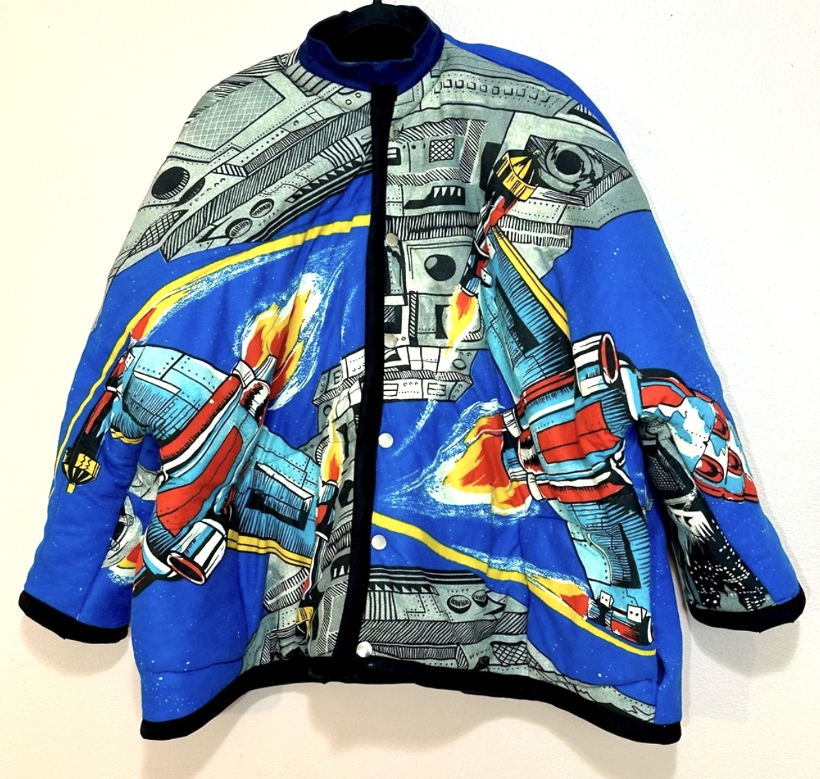 A blue jacket with a star wars design on it.
