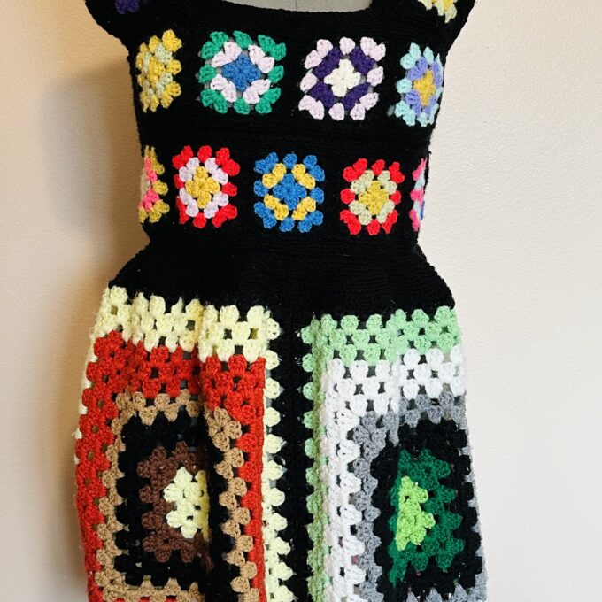 A crocheted dress on a mannequin dummy.