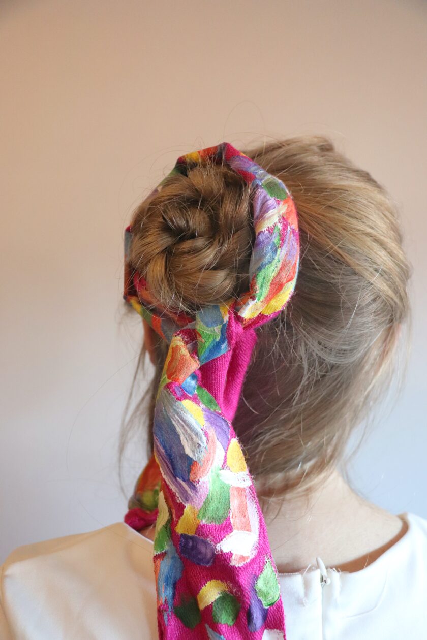 A woman with a colorful scarf in her hair.