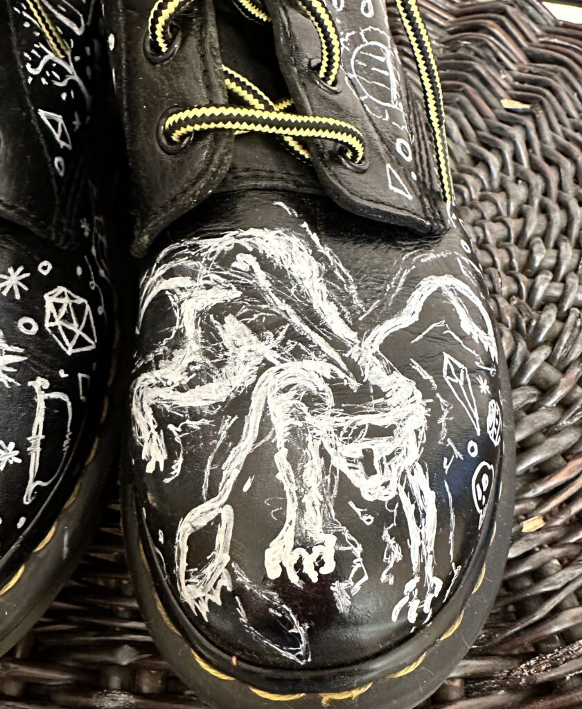 A pair of black shoes with white drawings on them.