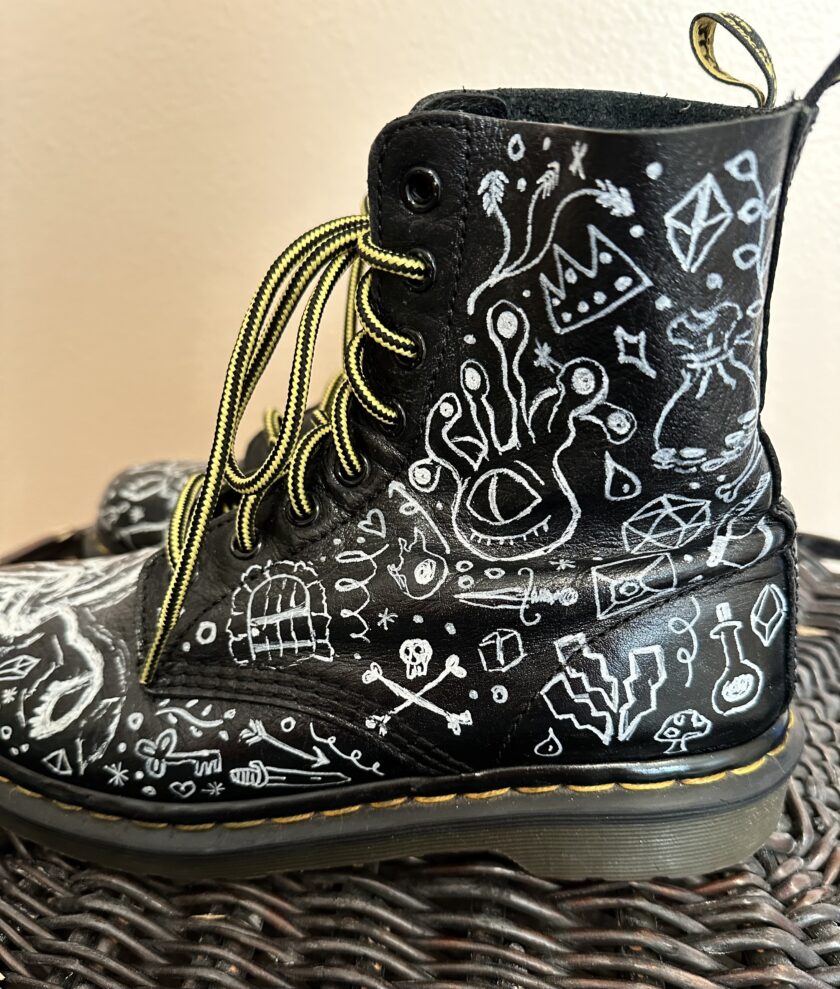 A black boot with white drawings on it.