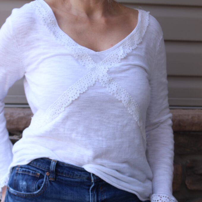 A woman wearing jeans and a white v - neck top.