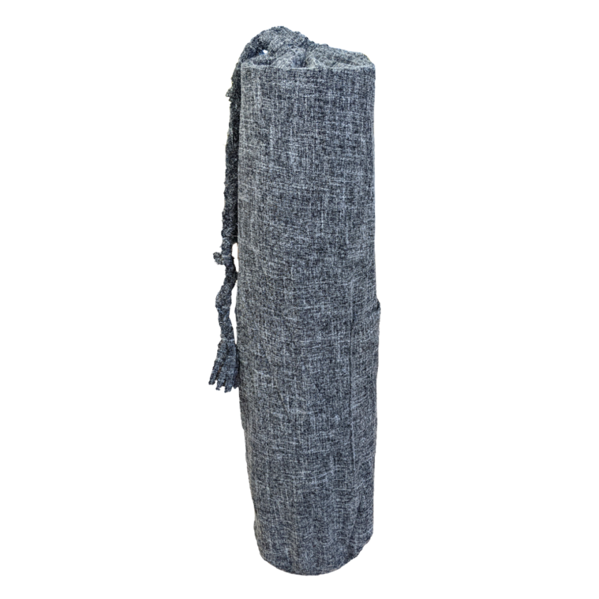 A grey yoga mat with tassels on it.
