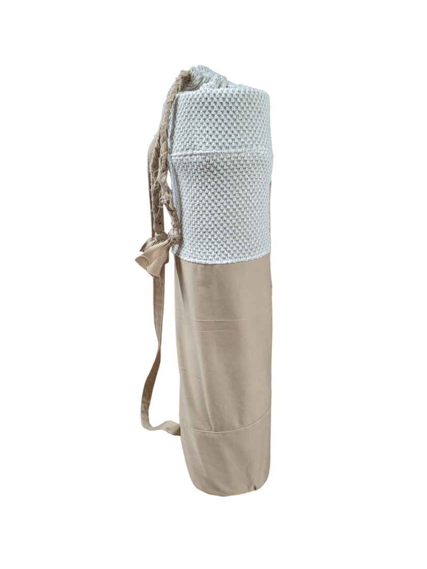 A beige and white yoga bag on a black background.
