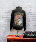 A pink floyd jacket on a stand next to a record player.