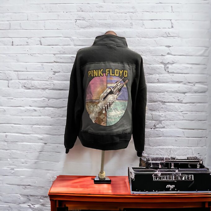 A pink floyd jacket on a stand next to a record player.