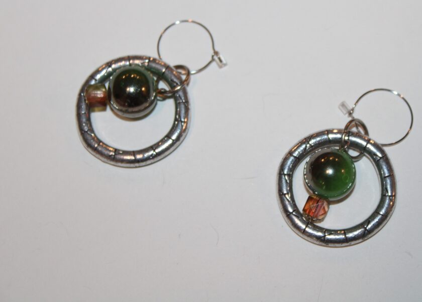 A pair of earrings with green and silver beads.