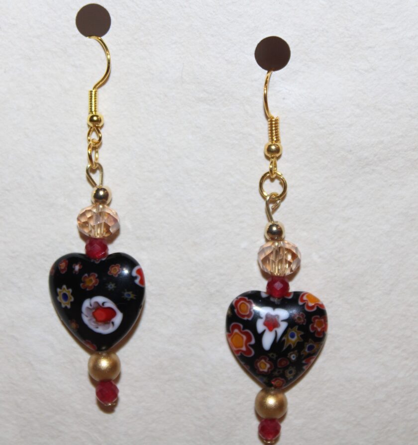 A pair of black and red heart shaped earrings.