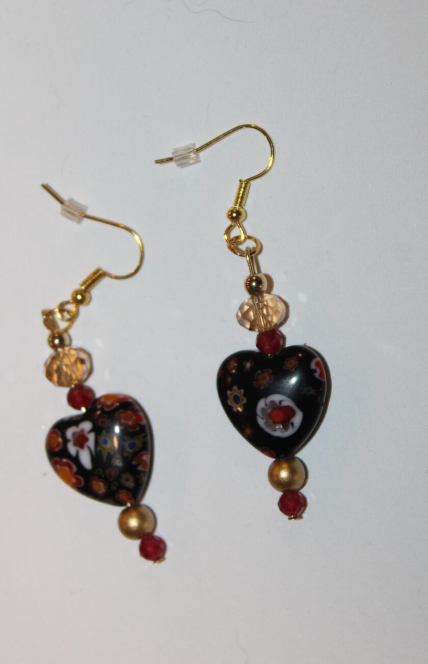 A pair of black and gold heart shaped earrings.