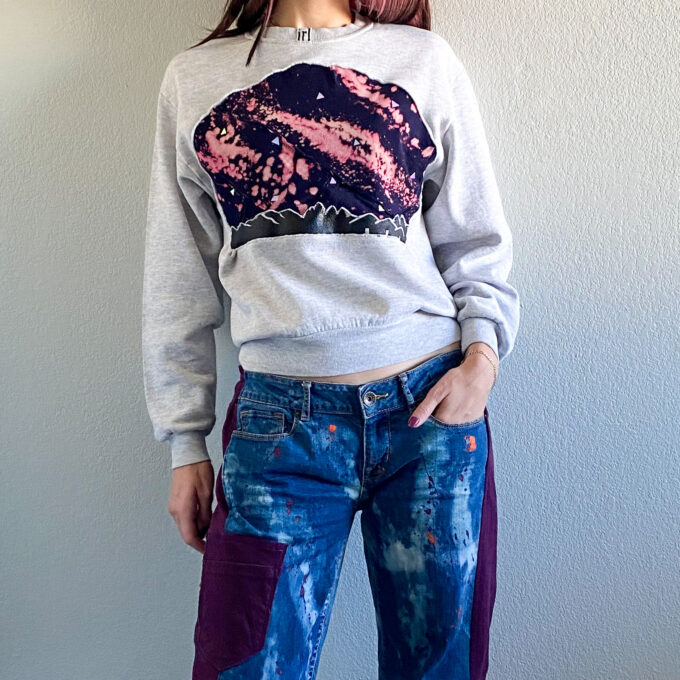 A woman wearing a sweatshirt and jeans.