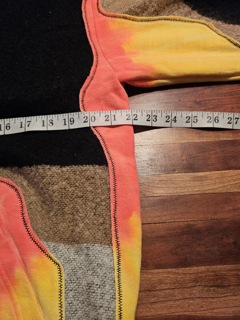 Measuring the waistband of a multicolored garment with a tape measure.