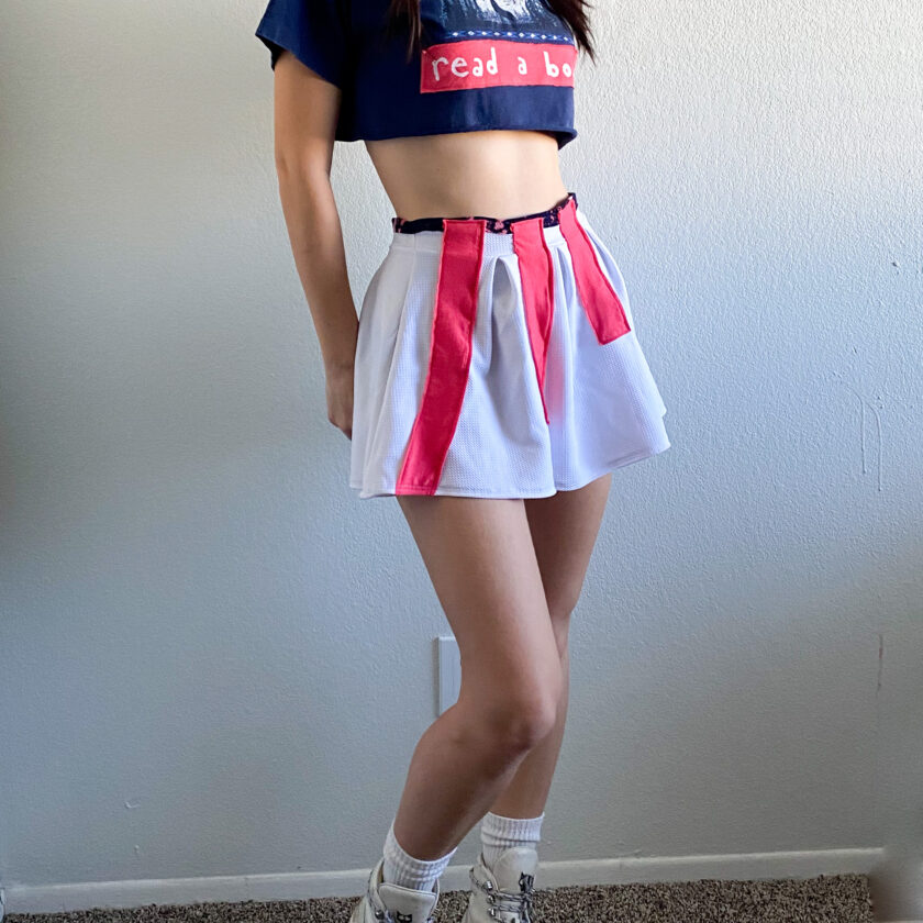 A girl wearing a crop top and skirt.