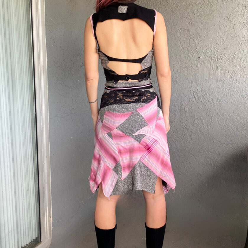 The back of a woman wearing a pink and grey plaid skirt.