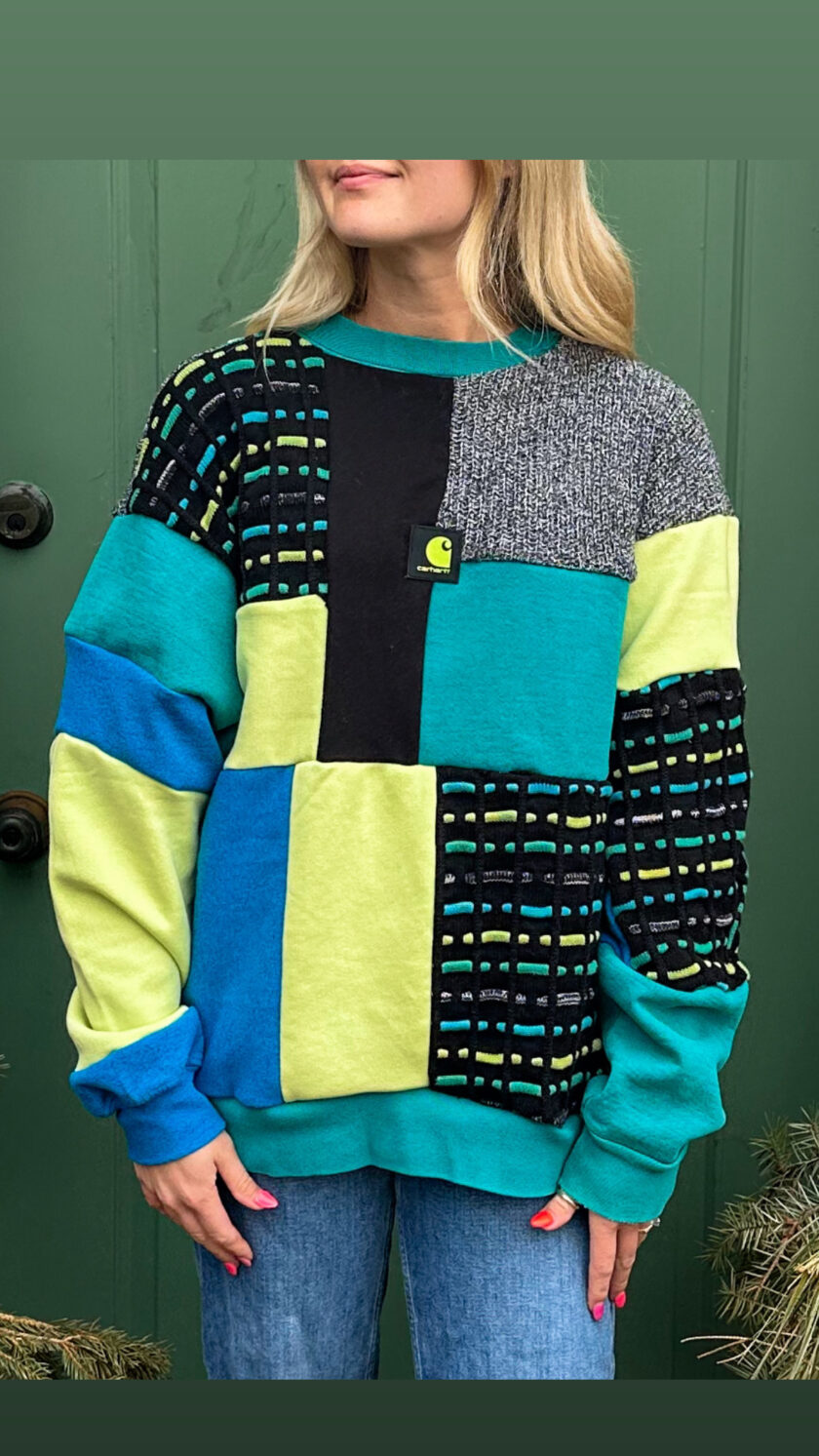 A woman wearing a blue, green, and black sweater.