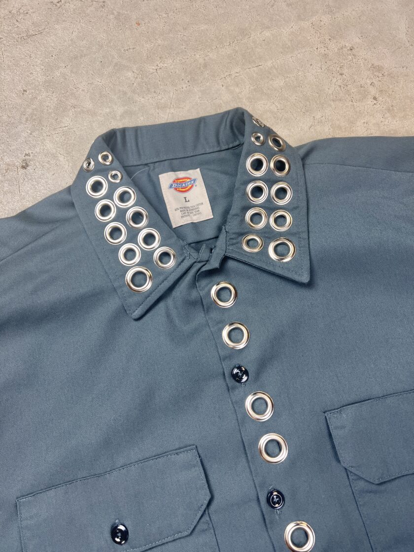 A blue shirt with silver buttons and studs.
