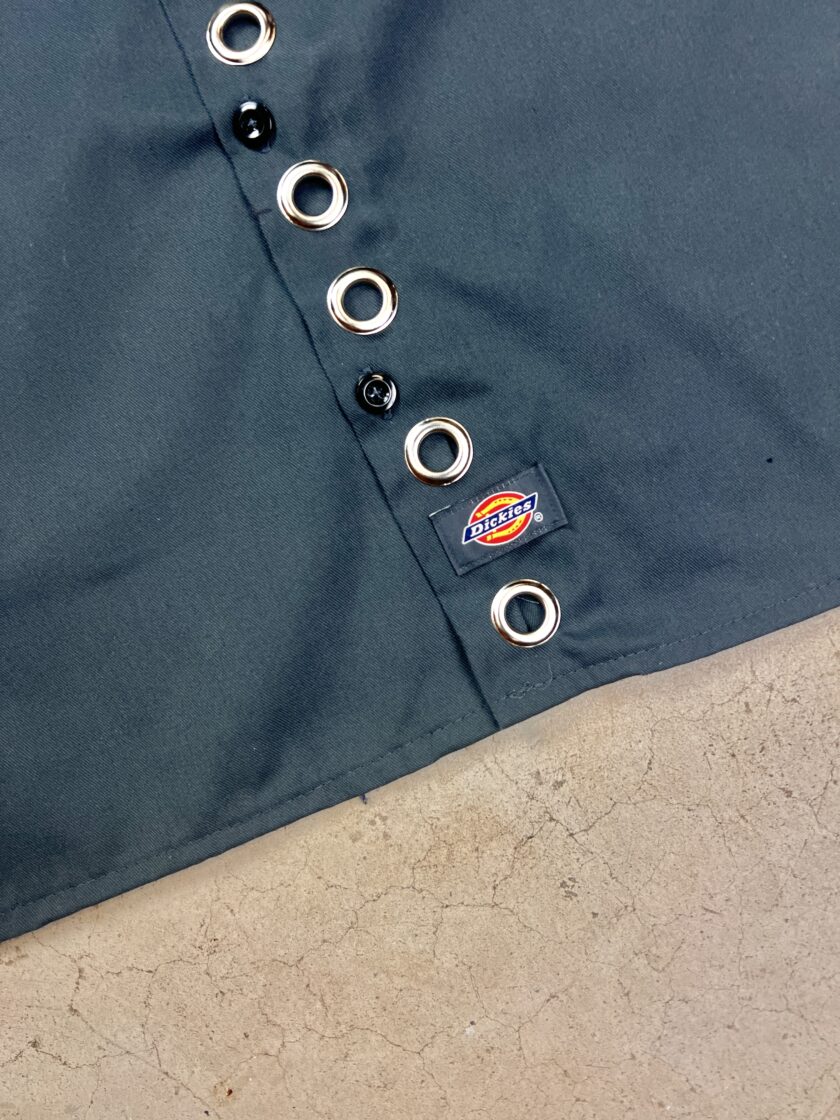 A black dickies apron with buttons on it.