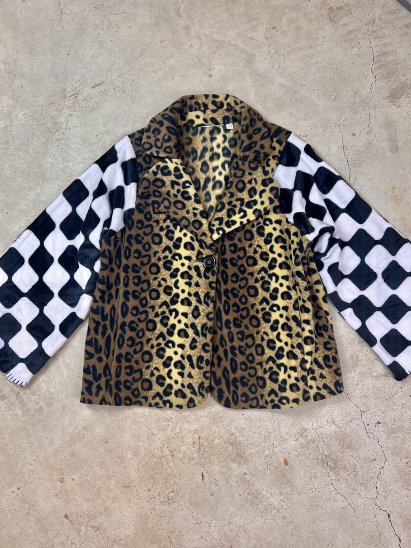 A leopard print jacket on a concrete surface.