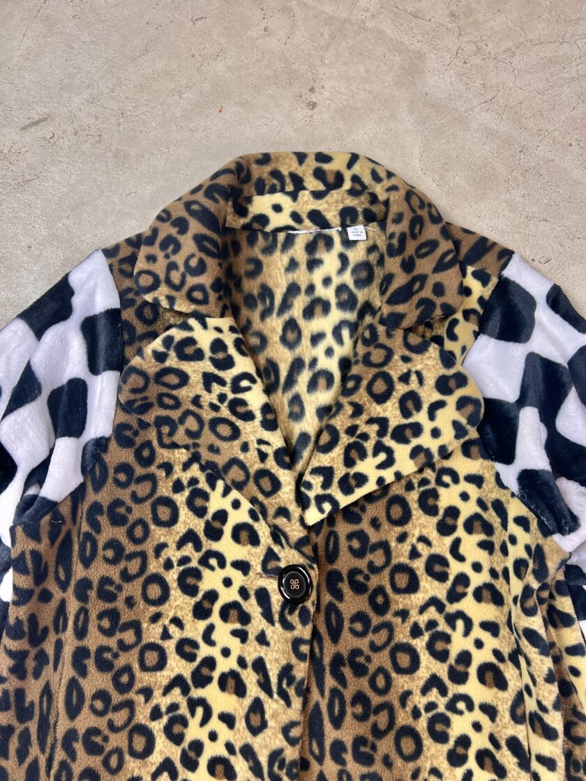 A leopard print coat on a concrete surface.