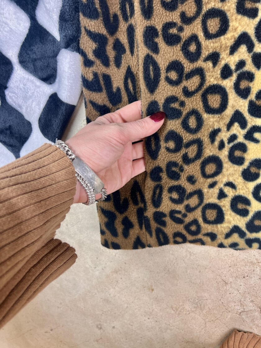 A person is holding a leopard print skirt.