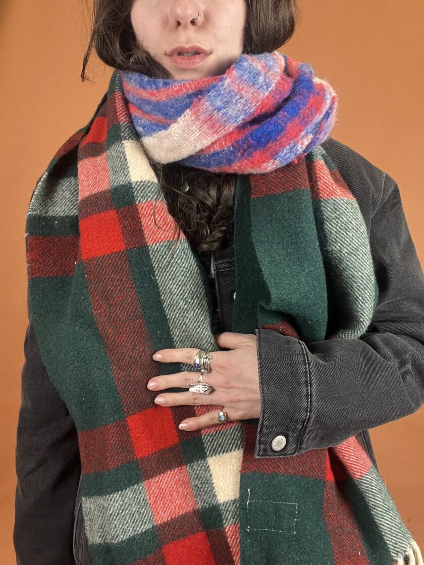 A woman wearing a red, blue and green plaid scarf.