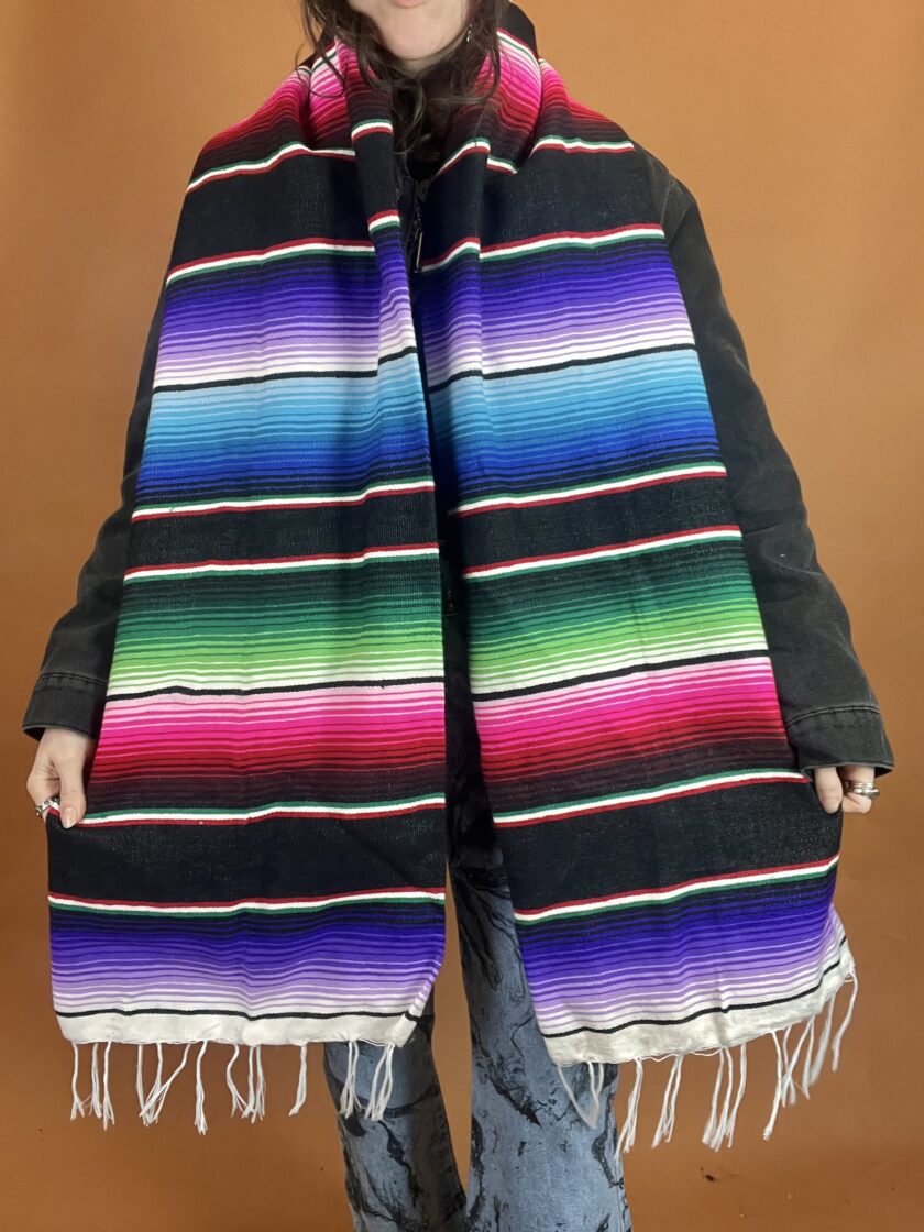 A woman wearing a colorful mexican scarf.