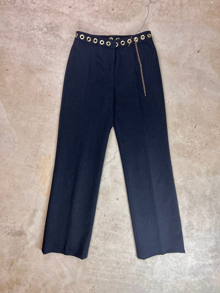 Navy blue trousers with a decorative gold chain and button details displayed on a neutral surface.