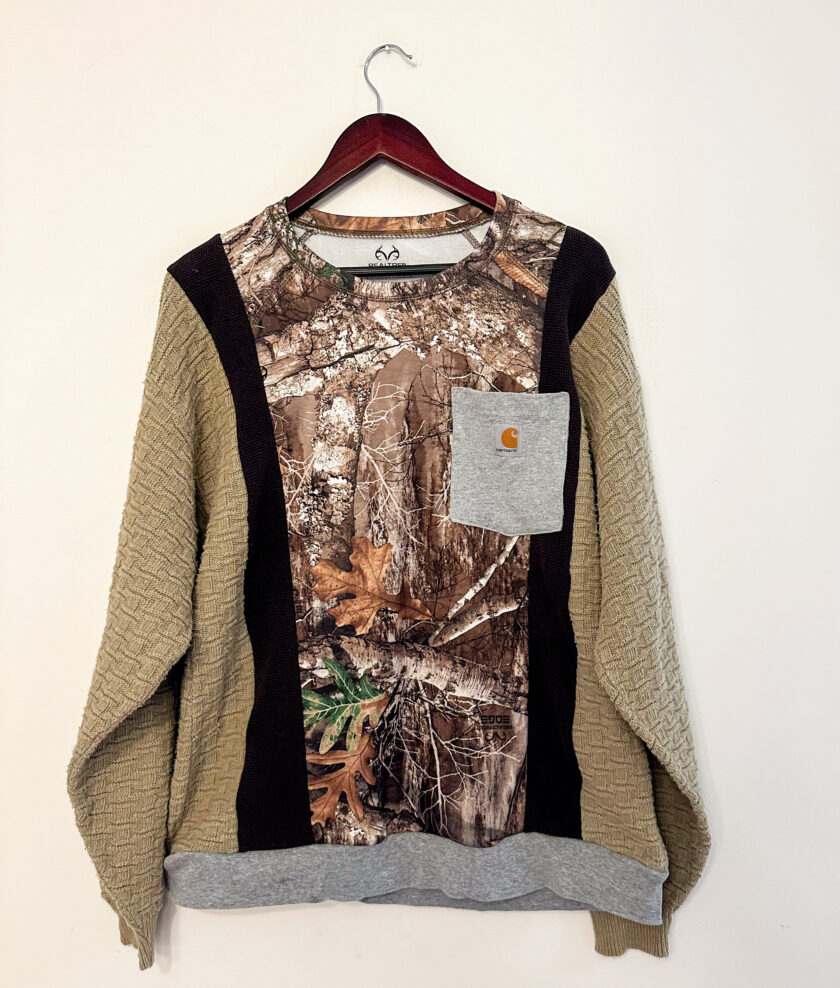 A sweater with a camouflage pattern and a pocket.
