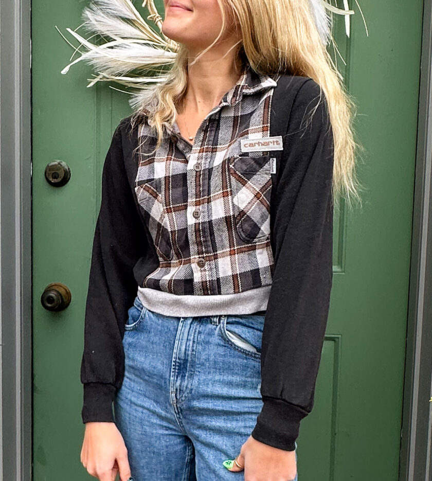 A blonde woman wearing jeans and a plaid shirt.