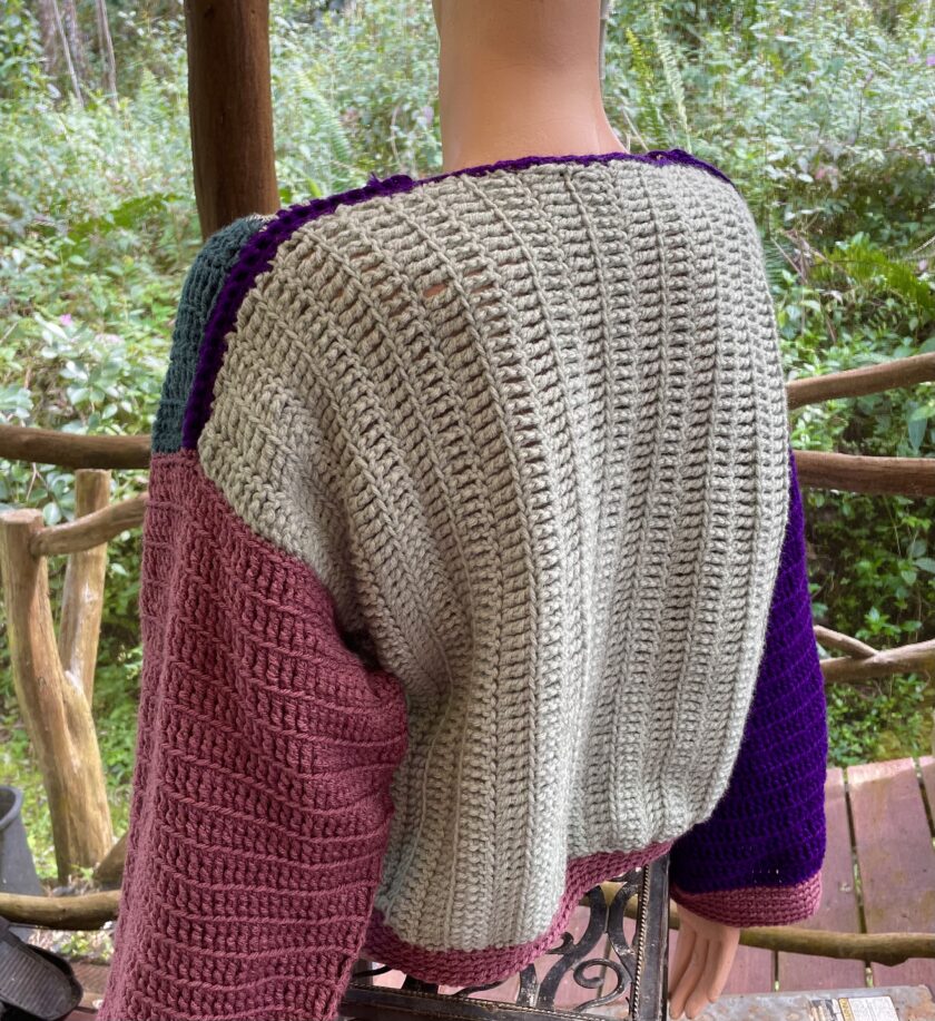 A mannequin mannequin wearing a crocheted sweater.