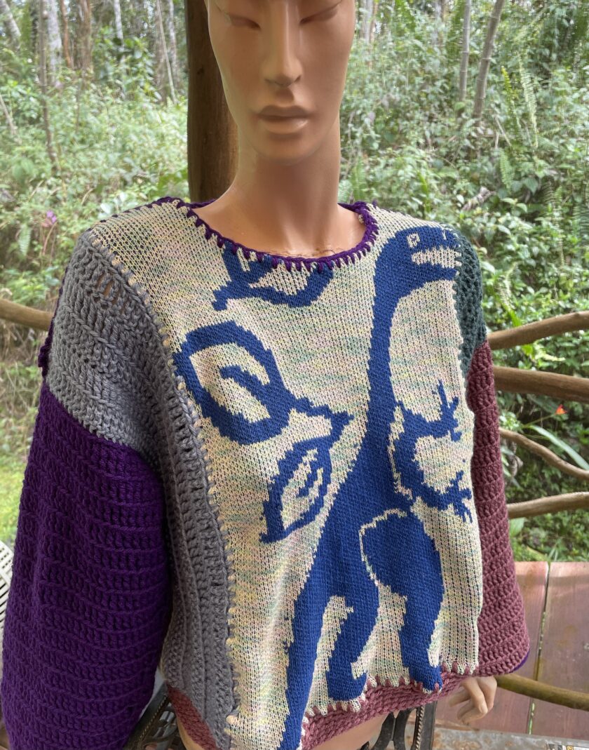 A mannequin wearing a sweater with dinosaurs on it.
