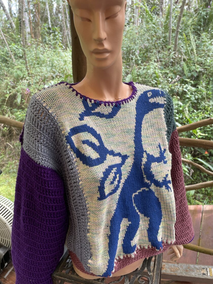 A mannequin wearing a sweater with a dinosaur on it.