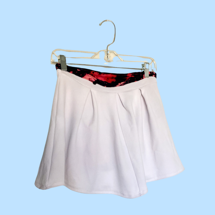 A white skirt hanging on a hanger.