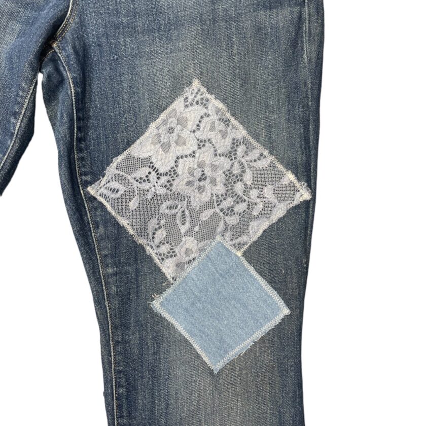 Denim jeans with a lace patch repair.