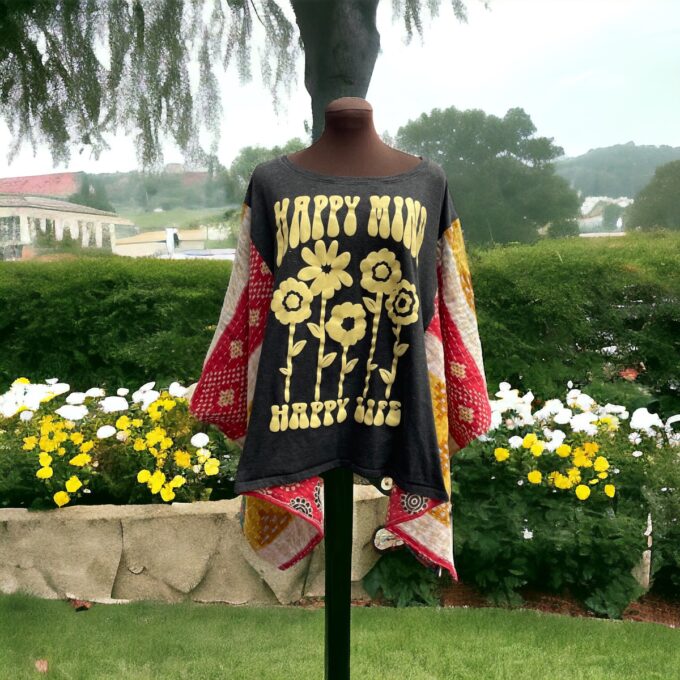A mannequin displays a floral patterned kimono with the text "happy mind happy life" in an outdoor setting with flowers in the background.