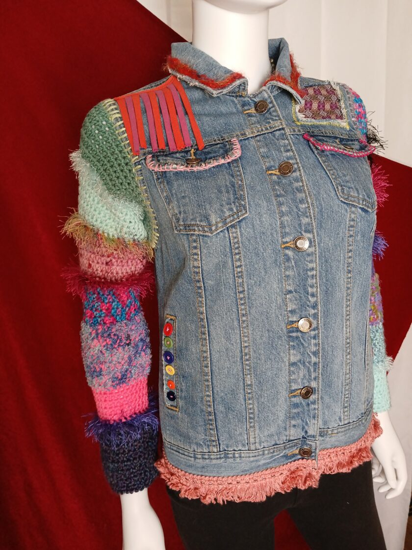 Colorful upcycled denim jacket with crochet sleeves, bold buttons and peach fringe
