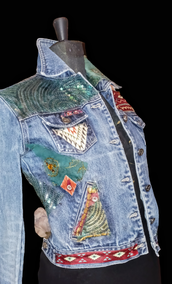 A denim jacket with embroidered patches on it.