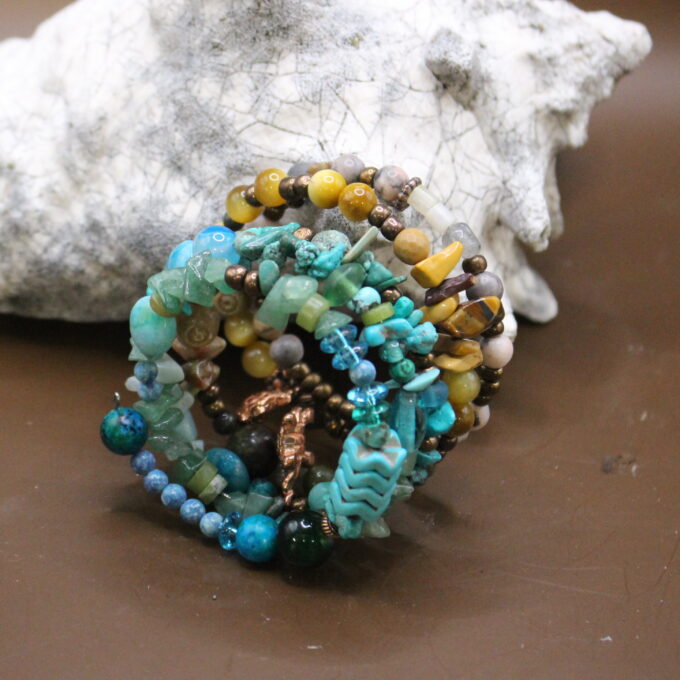 A handcrafted beaded bracelet with multicolored stones and charms.