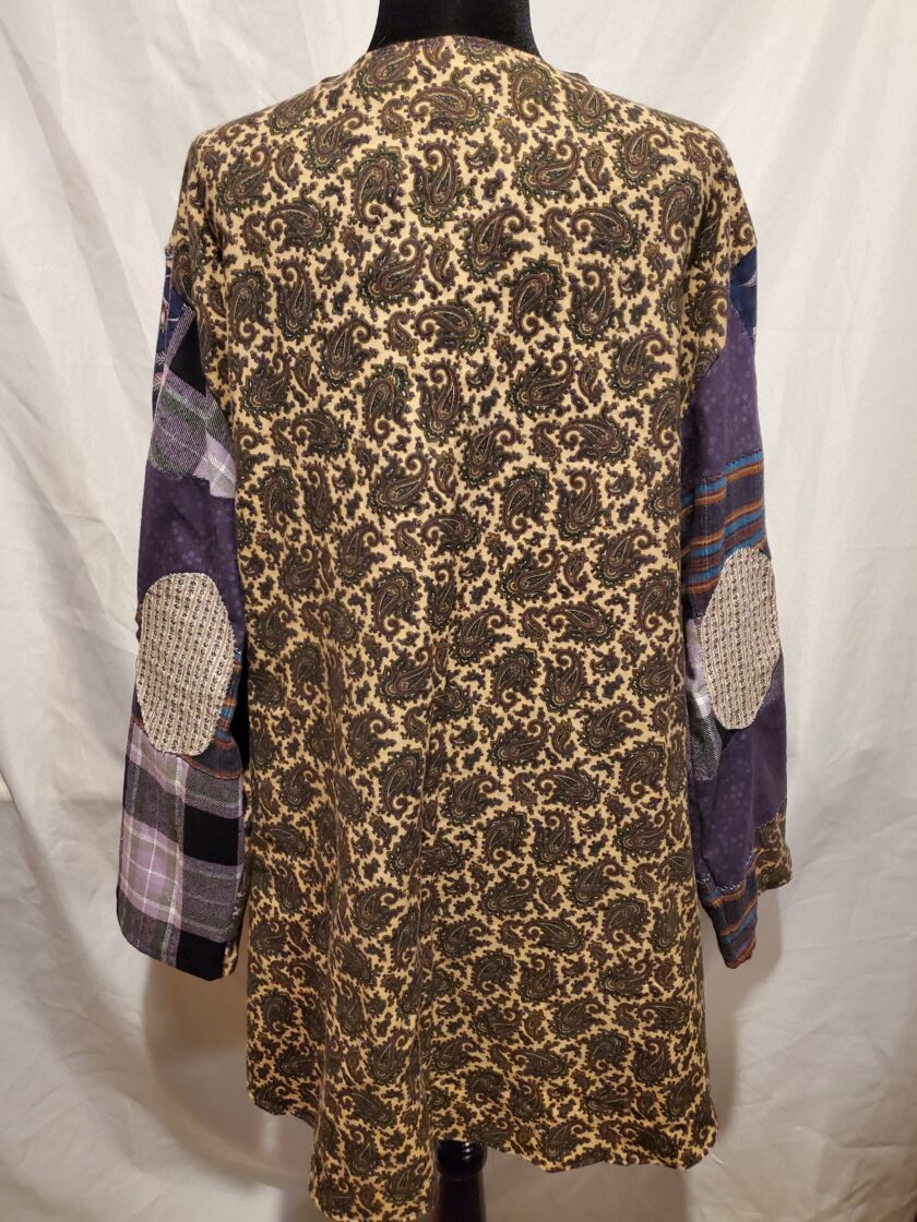 A mannequin displaying a long-sleeve, patterned shirt with a paisley and plaid design, photographed against a white background.