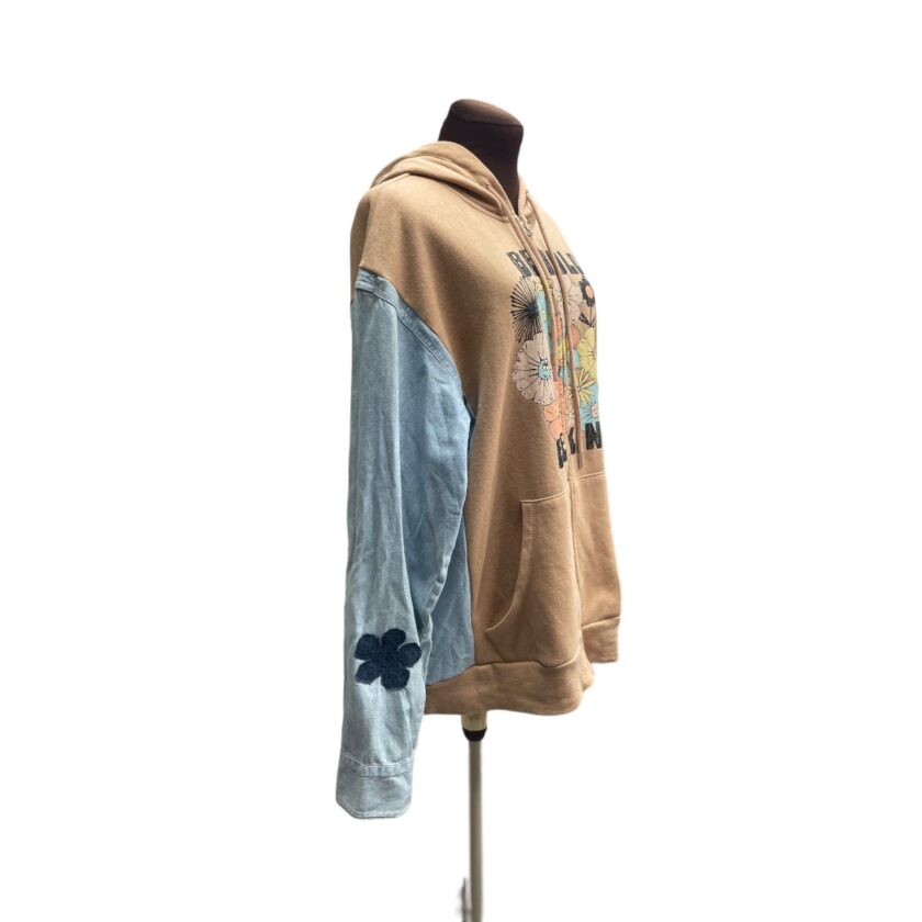 Mannequin wearing a patchwork hoodie with denim sleeves and graphic designs, displayed against a white background.
