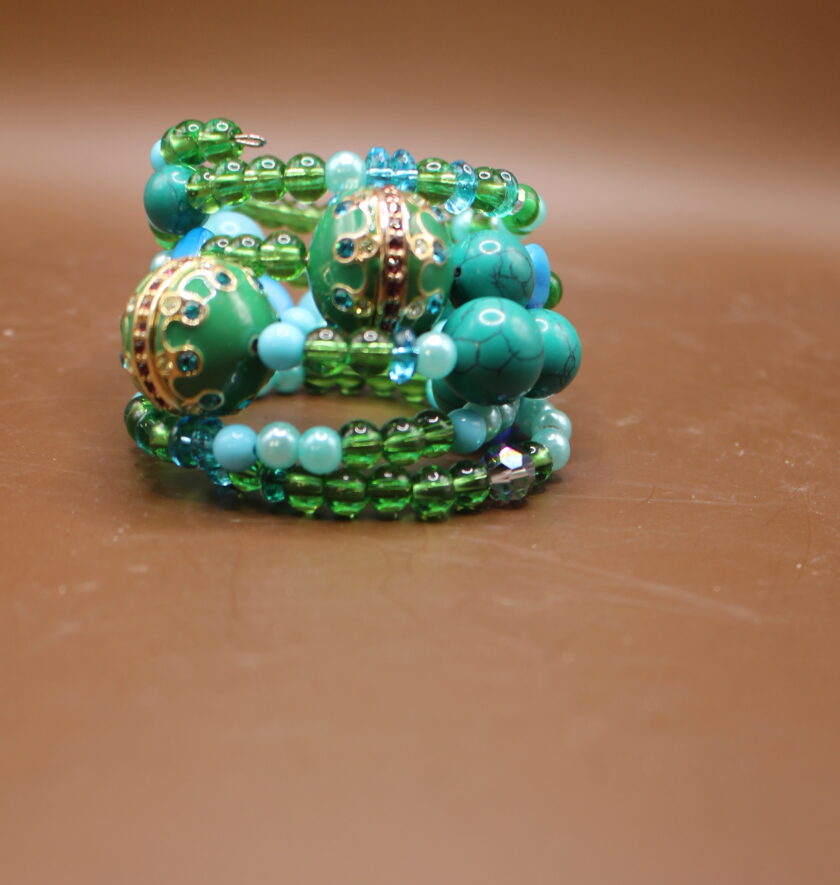 A pile of turquoise and green beaded jewelry on a brown surface.