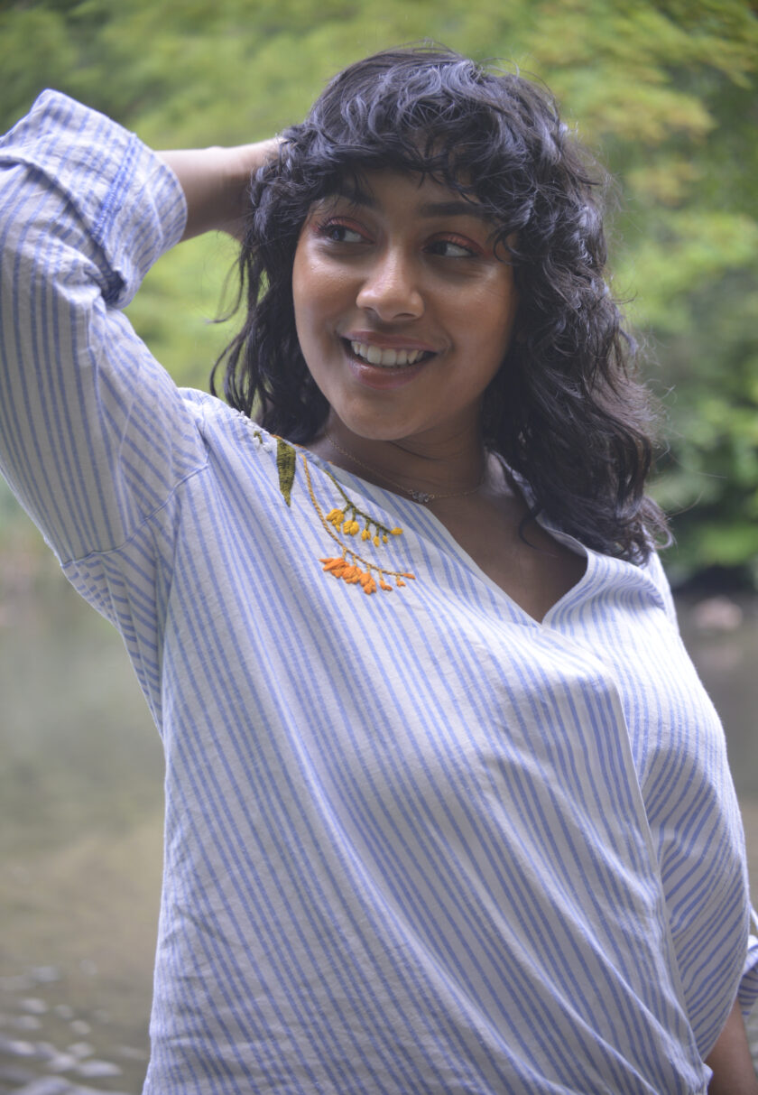 Pochoir.NYC blue and white striped linen wrap top embroidered with flowers at both shoulders.