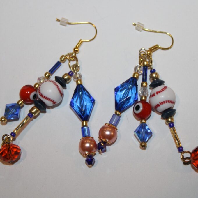 blue pierced dangle earrings with little baseballs, blue crystals and orange pearls and glass beads in three strands.