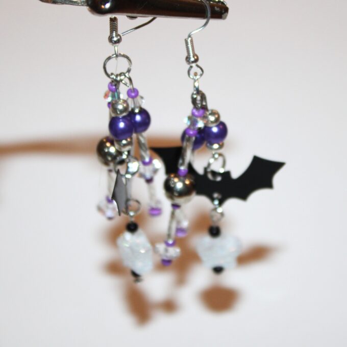 pierced earrings in silver tone with a little black bat and three dangles with purple pearls and purple glass beads